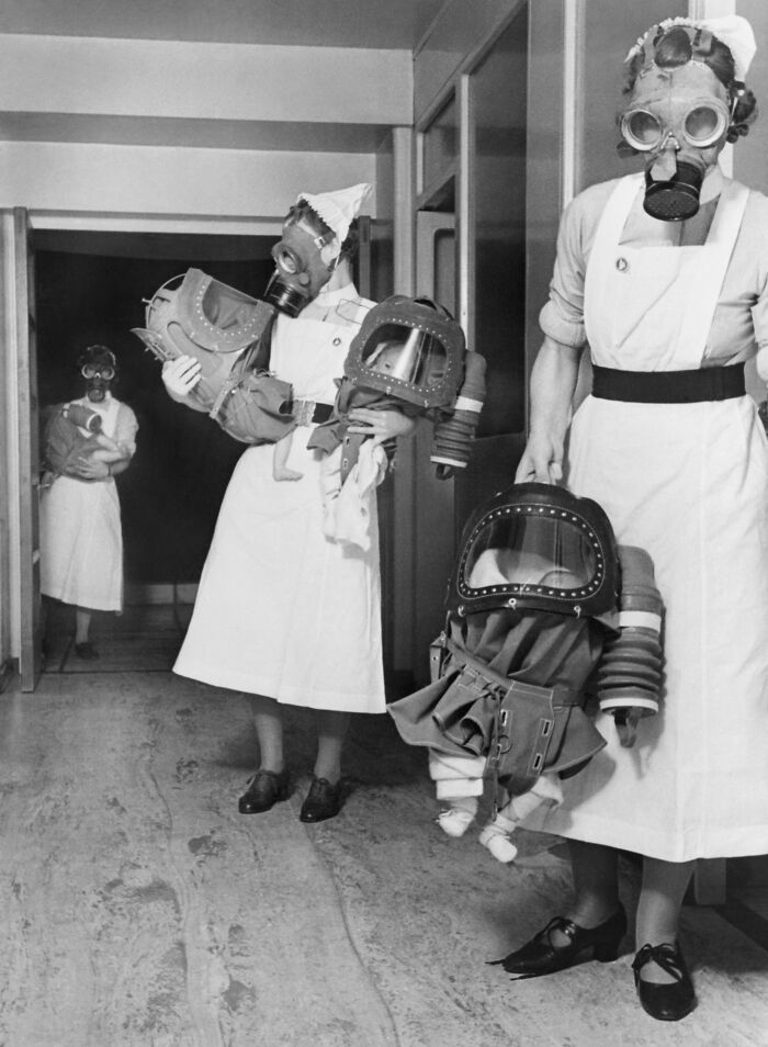 Nurses carrying babies in gas drills, 1940